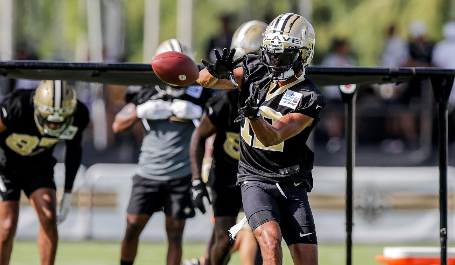 New Orleans Saints wide receiver Chris Olave wears his helmet showing an  American flag, Cuban flag and the Crucial Catch logo before an NFL football  game between the Saints and the Seattle