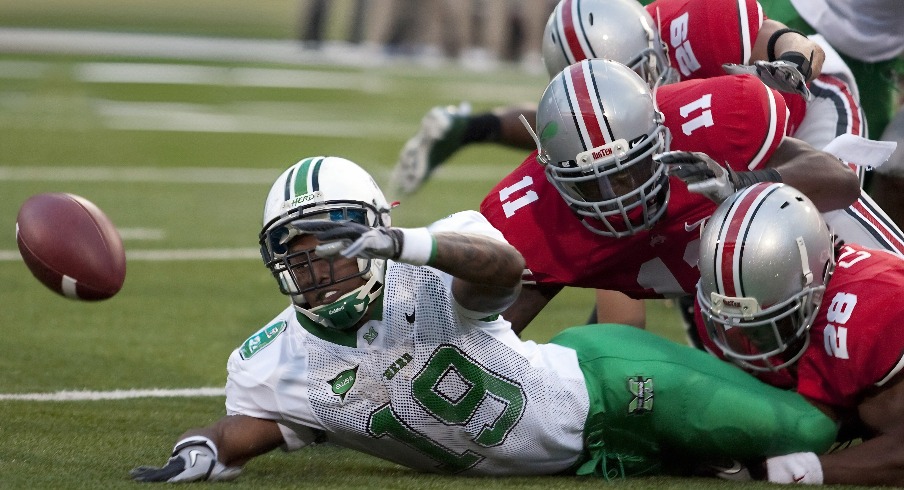 Sept 2, 2010; Columbus, OH, USA; Marshall Thundering Herd running back Andre Booker (19) fumbles while being tackled by Ohio State Buckeyes defensive back Dominic Clarke (28) and linebacker Dorian Bell (11) on the opening play of their game at Ohio Stadium. Greg Bartram-Imagn Image