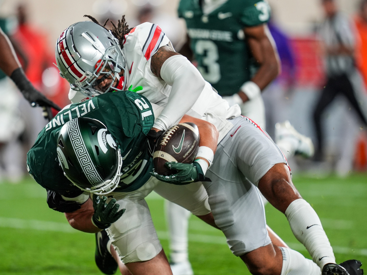 Ohio State Buckeyes cornerback Jordan Hancock (7) strips the ball from Michigan State Spartans tight end Jack Velling (12) during the second quarter the NCAA football game against Ohio State University at Spartan Stadium in East Lansing, Saturday, Sept. 28, 2024.