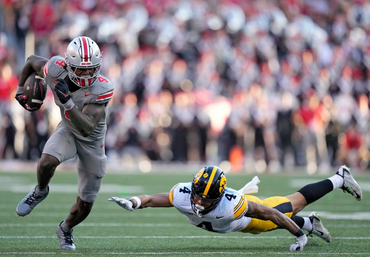 Oct 5, 2024; Columbus, OH, USA; Ohio State Buckeyes wide receiver Jeremiah Smith (4) gets past Iowa Hawkeyes defensive back Koen Entringer (4) after a catch in the third quarter during the NCAA football game at Ohio Stadium.