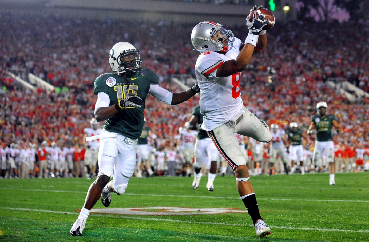 Jan. 1, 2010; Pasadena, CA, USA; Ohio State Buckeyes wide receiver DeVier Posey (8) catches a touchdown pass while being defended by Oregon Ducks linebacker Anthony Gildon (18) during the fourth quarter of the Rose Bowl game at the Rose Bowl. Mandatory Credit: Andrew Weber-Imagn Images