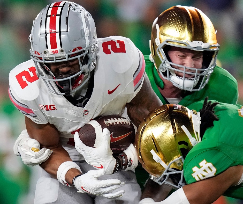 Sep 23, 2023; South Bend, Indiana, USA; Ohio State Buckeyes wide receiver Emeka Egbuka (2) makes a catch against Notre Dame Fighting Irish cornerback Cam Hart (5) and Notre Dame Fighting Irish linebacker JD Bertrand (27) during the fourth quarter of their game at Notre Dame Stadium.