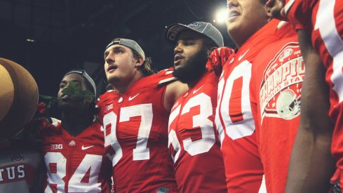 Joey Bosa and Michael Bennett sing Carmen Ohio with teammates following the Big Ten Championship game.