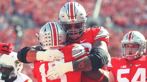 Taylor Decker hugs Ezekiel Elliott after a touchdown run against Hawai'i