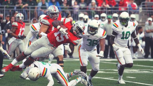 Ezekiel Elliott is upended by a Hawai'i defender.