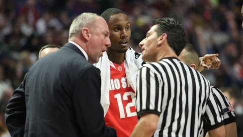 Thad Matta talks with an official.