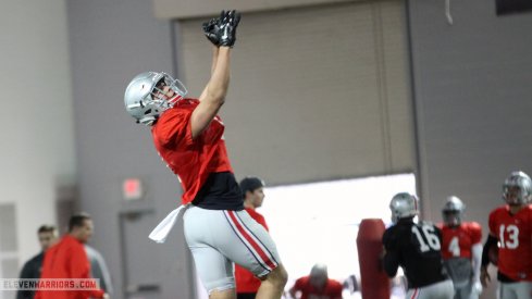 Austin Mack leaps to grab a pass during Tuesday's spring practice.