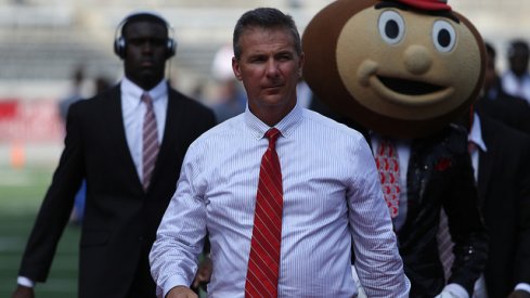 Urban Meyer rolls into Ohio Stadium with Brutus Buckeye.