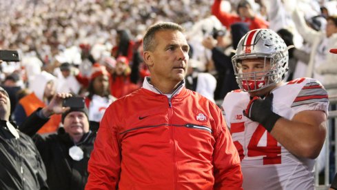 Urban Meyer guides his team onto the field. 