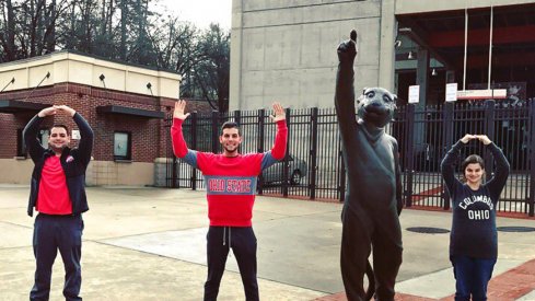 Ohio State student Corey Greenblat strikes the O–H–I–O pose with the Clemson tiger statue.