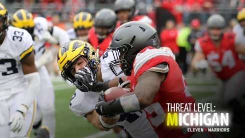 Ohio State running back Mike Weber stiffarms a Michigan Wolverine