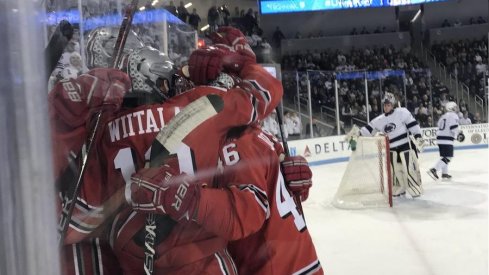 Sad Penn State goalie looks on as the Buckeyes celebrate one of their five goals.