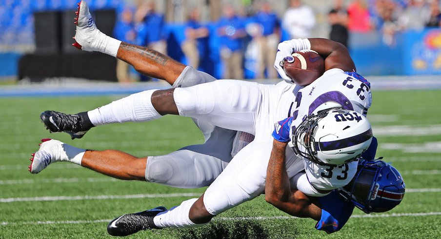 TCU running back Sewo Onilula is tackled by Kansas safety Jeremiah McCullough.