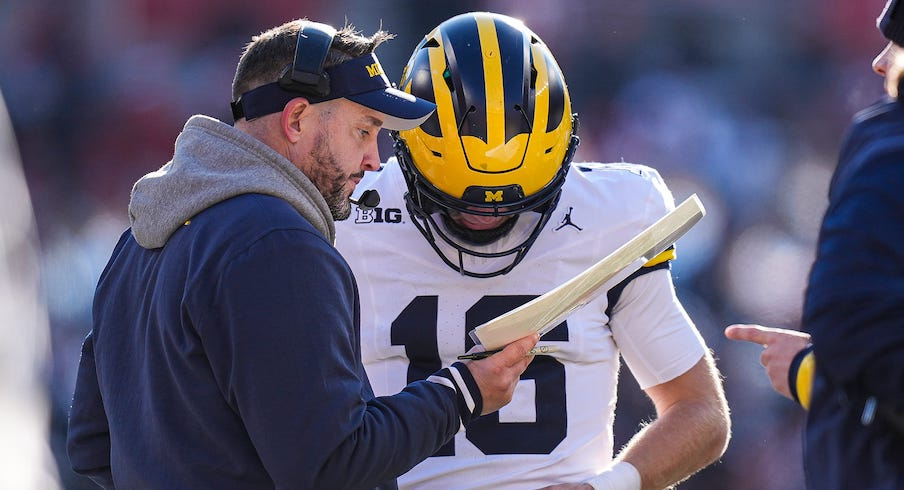 Kirk Campbell talking to Davis Warren during the Wolverines’ win over Ohio State