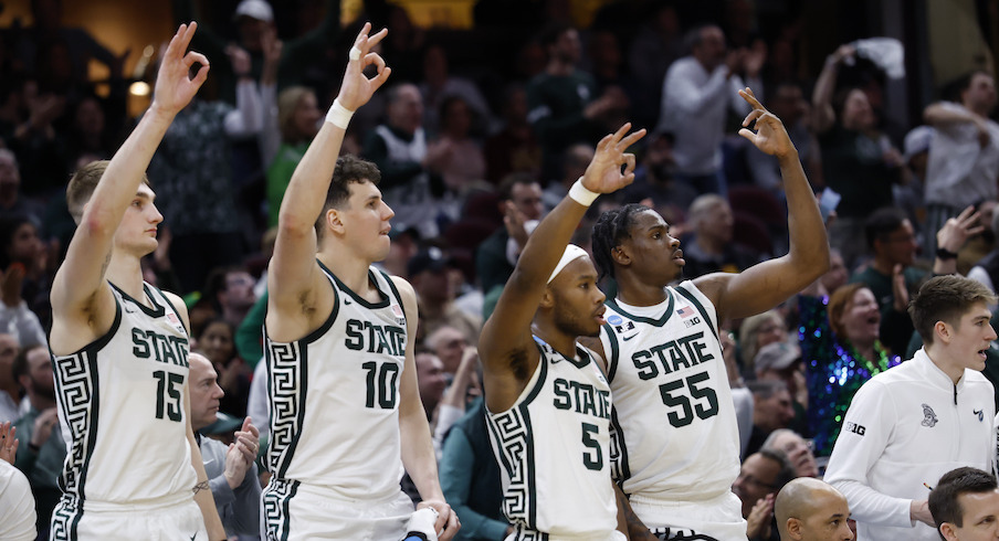 Michigan State players celebrating on the bench